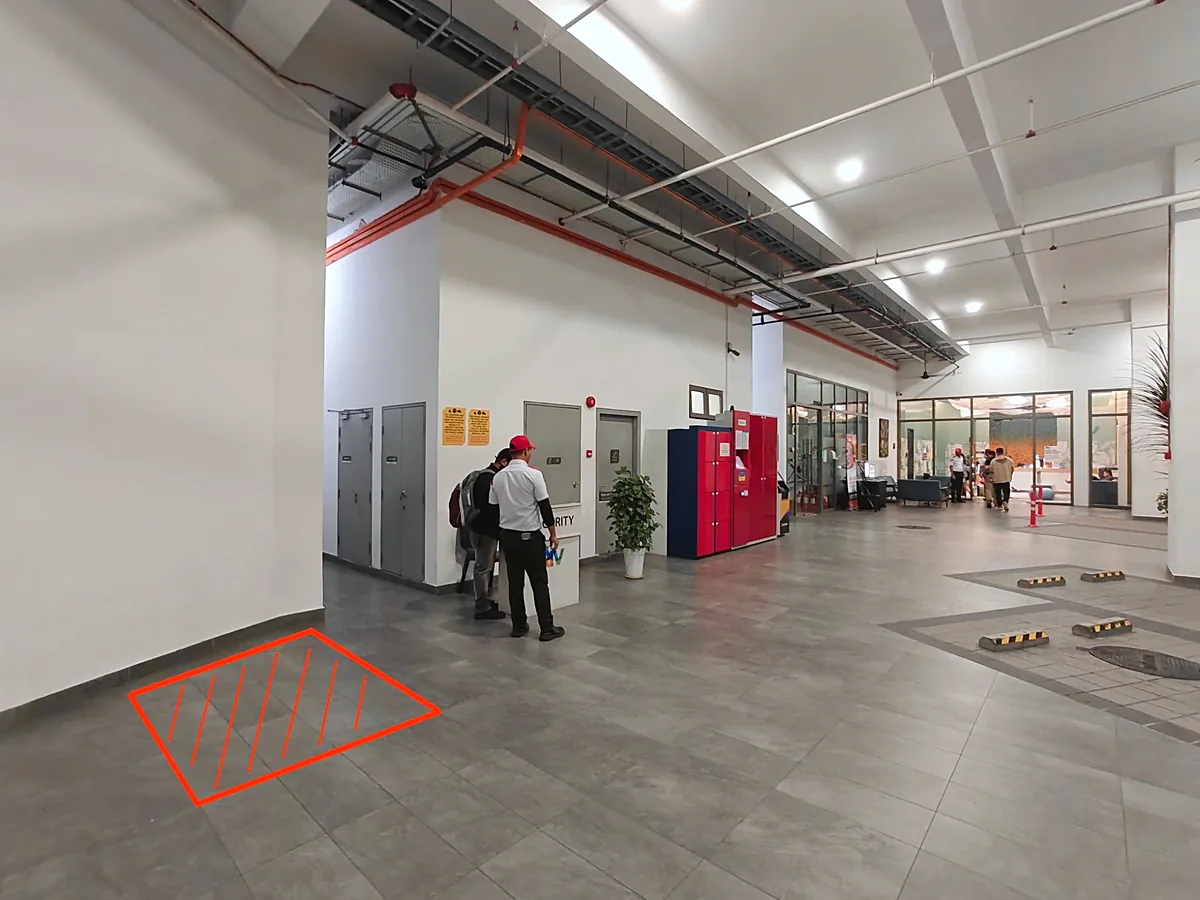A building lobby with a red outline on the floor marking the space to rent